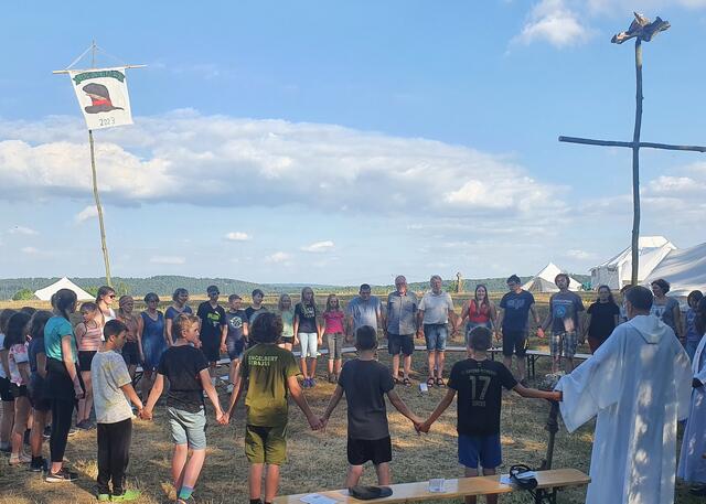 Beim „Vater unser“ im Lagergottesdienst fassten sich alle an die Hand, die Pfarrer Hardy Hawinkels und Patrick Mwanguhya beteten vor, Communio-Schwester Anna Joyce aus Tansania trommelte und sang mit der Gemeinde afrikanische Lieder.  | Foto: Manfred Lang/pp/Agentur ProfiPress
