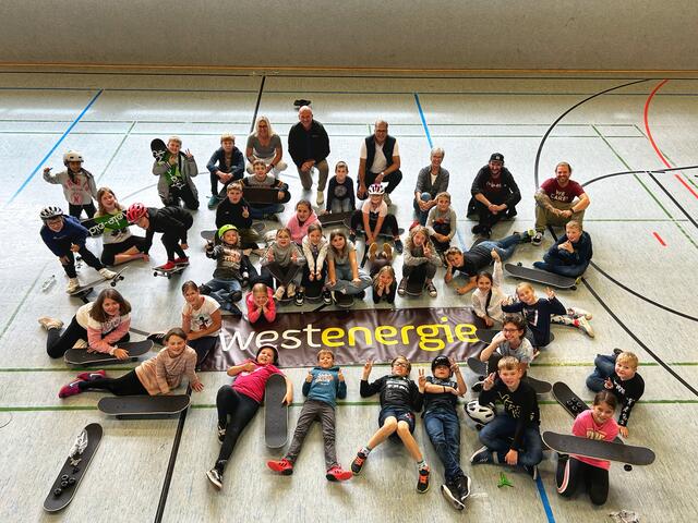 Bürgermeister Ulf Hürtgen und Achim  Diewald, Kommunalmanager bei Westenergie (beide Mitte hinten), sowie Annette Jülich-Meiser und Maria Imöhl-Bäumer vom Orga-Team der Stadtranderholung freuten sich mit den Kindern und den erfahrenen Trainern von „skate-aid“ über die Fortschritte beim Skateboarden. | Foto: Stadt Zülpich/Torsten Beulen