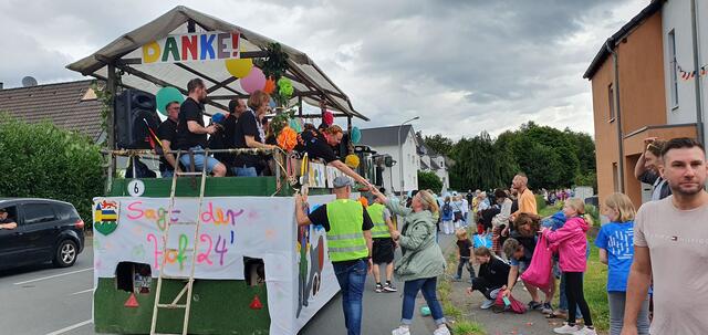 Der Hofstaat 2024 um Dorfkönigspaar Nadine und Marcel Winzer verteilte ebenso großzügig Geschenke und Süßigkeiten unter die wartenden Zuschauer, wie die meisten der anderen 300 Zugteilnehmer.  | Foto: Gabi Knops-Feiler