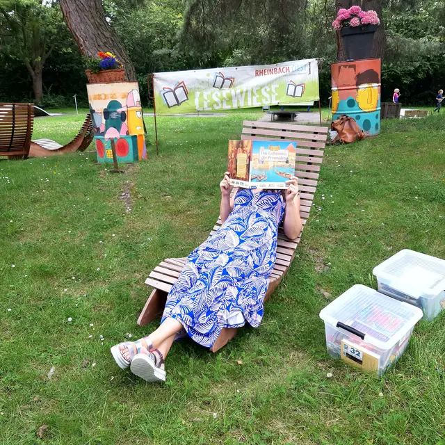 Sommer, Sonne, Lesegenuss: Unter schattigen Bäumen lädt die Lesewiese im Rheinbacher Freizeitpark zum Schmökern und Entspannen ein – Bücherkisten für Groß und Klein inklusive. | Foto: Rheinbach Liest e.V.