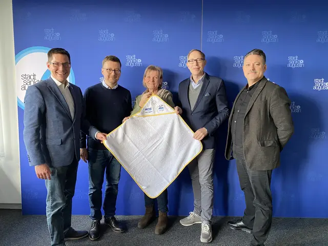 Bürgermeister Dr. Max Leitterstorf, Erster Beigeordneter Martin Eßer, Josefine Rosenberg (Fachdienstleiterin Soziale Dienste), Marcus Lübken (Geschäftsführer WVG) und Rainer Wind (Koordinator Netzwerk Frühe Hilfen und Projekte, v.li.) präsentieren das Babyhandtuch. | Foto: Stadt Sankt Augustin