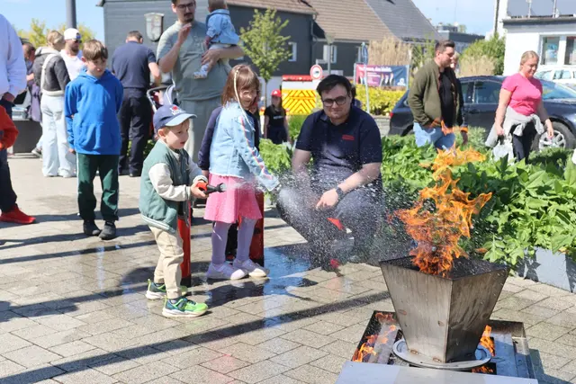 Emilia (6) und Ruben (4) haben Spaß beim Feuerlöschen mit Feuerwehrmann Jan Köstering | Foto: Michael Kupper