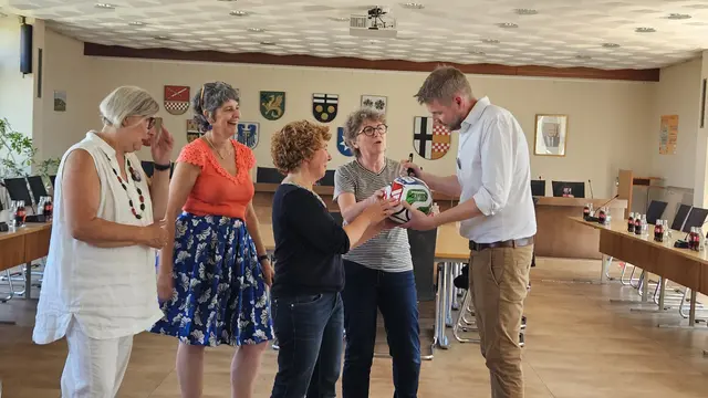 Den WM-Fußball als Gastgeschenk für den bekennenden FC-Fan und Bürgermeister Tobias Leuning hätten die Damen aus Frankreich, die neue Bürgermeisterin Béatrice Prouvost und ihre Vorgängerin Rose Marie Hallynck nicht passender wählen können.  | Foto: Partnerschaftsverein