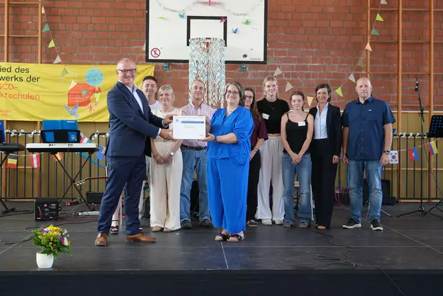 Lutz Möller, stellvertretender Generalsekretär der deutschen UNESCO-Kommission, überreichte die Urkunde an die Schulgemeinschaft um Schulleiterin Julia Franken. | Foto: Stadt Erftstadt/Krausen