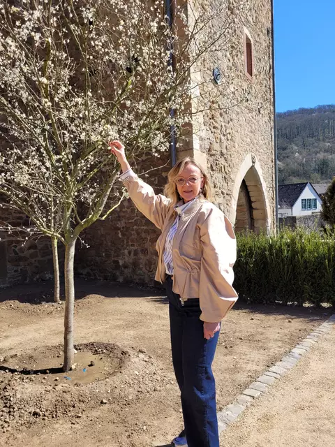 Über die ersten Blüten an den Obstbäumen im Bauerngarten freut sich Bürgermeisterin Sabine Preiser-Marian.  | Foto: Mager/Stadt Bad Münstereifel