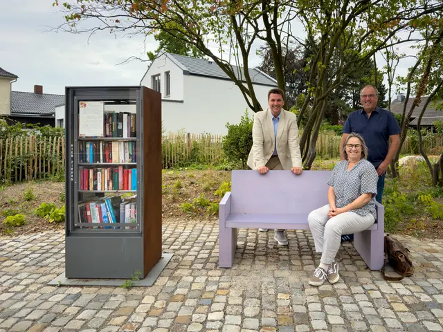 Genießen den neuen Aufenthaltsort am Bücherschrank: Bürgermeister Alexander Biber (links) und Ortsvorsteher Wolfgang Weithe-Berchtold (rechts) mit Kerstin Kuffner (sitzend auf der Bank, Sachgebiet Grünplanung und -neubau). | Foto: Stadt Troisdorf