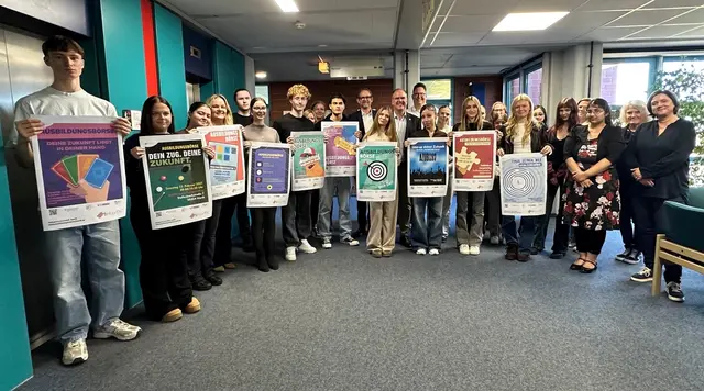 Die Schülerinnen und Schüler präsentierten fürs Gruppenfoto mit Vertreterinnen und Vertretern der Jury ihre Plakatentwürfe für die 29-ste Ausbildungsbörse.  | Foto: Stadt Hürth