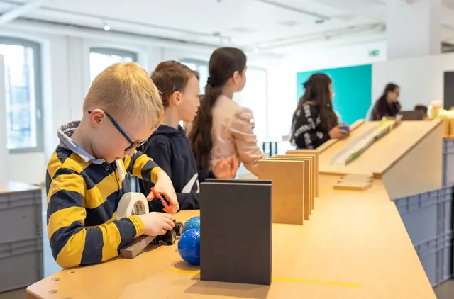 Kinder experimentieren mit verschiedenen Materialien und bauen gemeinsam an einer Kettenreaktion. | Foto: S. Arendt
