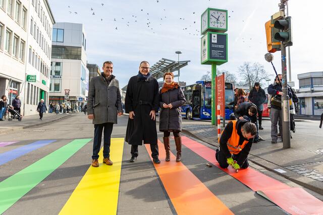 Oberbürgermeisterin Katja Dörner, Bezirksbürgermeister Jochen Reeh-Schall und Carsten Sperling, Leiter der Straßenverkehrsbehörde, besuchten die Markierungsarbeiten für den neuen Regenbogenübergang.  | Foto: Giacomo Zucca/Bundesstadt Bonn