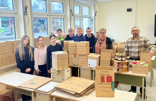 EDie Jugendlichen packten eifrig Päckchen. Zu sehen sind Schülerinnen und Schüler der Jahrgangsstufe 9, Schulleiterin Christa Sostmann und der Religionslehrer Peter Hildebrandt.  | Foto: Suna Bekjiri