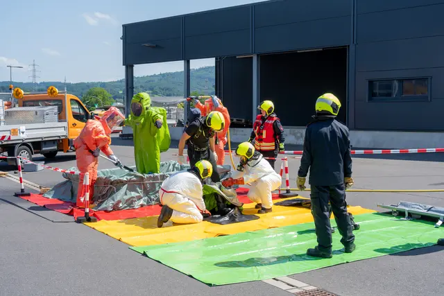 Schauübung zu einem verunglückten Gefahrentransport mit Säureladung. Hier werden die Einsatzkräfte (grüner Schutzanzug) dekontaminiert. | Foto: Heimermann