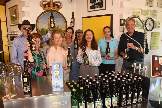 Eine tolle Idee ist die Jubiläumsflasche aus Anlass des 100-jährigen Bad-Bestehens, die ab sofort im Draitschbrunnen-Gebäude an der Brunnenallee zum Kauf angeboten ist. 1 Euro gehen vom Kaufpreis als Spende ans Hermann-Josef-Haus. Helmut Fiehl (links hinten), seine Tochter Bettina Kalz (2.v.l.) und Schwiegersohn Reinhard Kalz (ganz rechts) hatten die Idee. Dr. Iris Henseler-Unger und Bernd Birkholz vom VHH freuten sich mit Britta Pitsch und Feyza Yildiz.  | Foto: AS