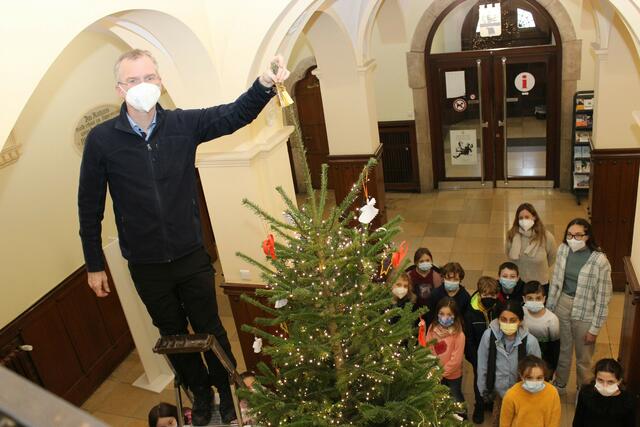 Als Bürgermeister Frank Stein vor dem Baum stand, stellten die Kinder und er fest, dass auf der Spitze noch Dekoration fehlte. . | Foto: Stadt Bergisch Gladbach