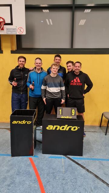 Das Foto zeigt die erfolgreiche Aufsteiger-Mannschaft von links nach rechts mit den Spielern Jan-Lukas Hinrichs, Bernd Hersel, Tobias Amtenbrink, Uwe Peters, Marc Hecht sowie Jörn Kampf und teilweise bereits mit einem verdienten Gewinner-Kaltgetränk. | Foto: TTG