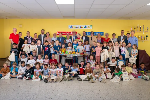 Übergabe der Erstlesetaschen an die i-Dötzchen der Deutschherrenschule in Hürth-Hermülheim mit Bürgermeister Dirk Breuer (Mitte), der Vorsitzenden der Lesefreunde Hürth Ulla Buse (links), Schulleiterin Kerstin Schiel (rechts), Vertreterinnen und Vertretern der Stadt Hürth, Mitgliedern der Lesefreunde, Lesementorinnen sowie Vertreterinnen und Vertretern der Förderer.  | Foto: Bild: Stadt Hürth/Giuseppe Piliero