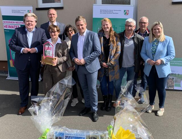 Staatssekretär Dr. Jan Heinisch (2.v.l.) übergab den Landes-Heimat-Preis 2022 an Simone Böhm (vorne, 3.v.l.) als langjährige und engagierte Vorsitzende des Ortskartells. Mit ihr freuten sich u.a. der Landtagsabgeordnete Klaus Voussem (l.), Landrat Markus Ramers (Mitte), Ortsvorsteherin Judith Maur (4.v.r.) und Bürgermeisterin Jennifer Meuren (r.).