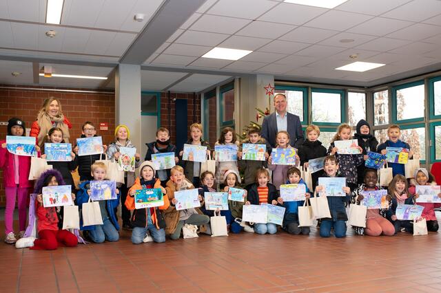 Bürgermeister Dirk Breuer umringt von den Schülerinnen und Schülern, der Brüder Grimm-Gemeinschaftsgrundschule  Gleuel,  die  an  dem  städtischen  Weihnachtskarten-Malwettbewerb teilgenommen haben. Das Bild von Gewinner Mats Höller (4. von links mit gelber Mütze) wird auf die Weihnachtsgrußkarte der Stadt Hürth gedruckt.  | Foto: Stadt Hürth / Giuseppe Piliero