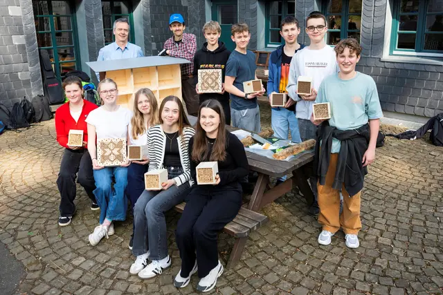 Der Biologie-Kurs der neunten Klasse des St.-Angela-Gymnasiums mit Lehrer Norbert Tekotte und Rudolf Hillen vom NABU Oberberg mit den Einsätzen für das Insektenhotel.  | Foto: Foto Jens Knipp