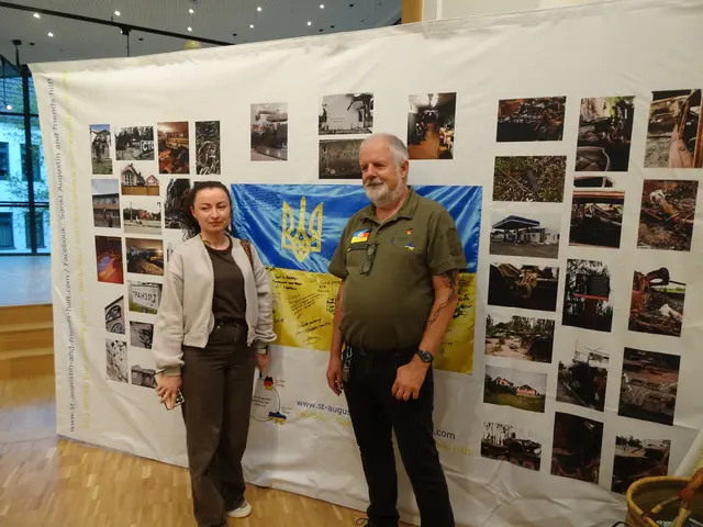 Eine Wand mit Fotos, die von Kindern des 6. bis 8. Schuljahres angefertigt wurden mit Motiven aus ihrer Umgebung, die für sie die Kriegssituation besonders darstellen. Davor Herr Maassen mir einer Einwohnerin der Region Charkiw. | Foto: K.-J. Will