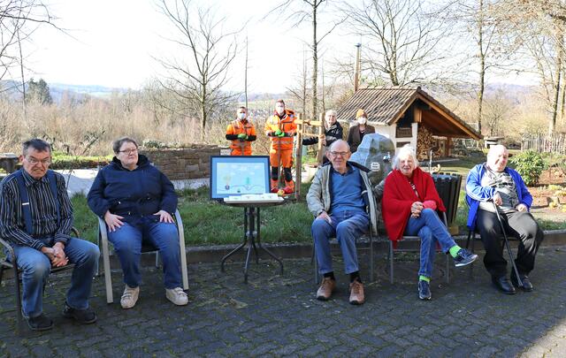 Lasse Neuburg und Matthias Heuer von der Stadt Wiehl mit HBW-Bewohner Heinz Gerd Rees und Petra Kaufmann (Pädagogische Leitung HBW). Bewohner*innen des „Hauses am Konradsberg“ platzierten sich neben dem Tisch mit Bild und Postkarten des Friedensbaums.  | Foto: HBW/F. Jansen