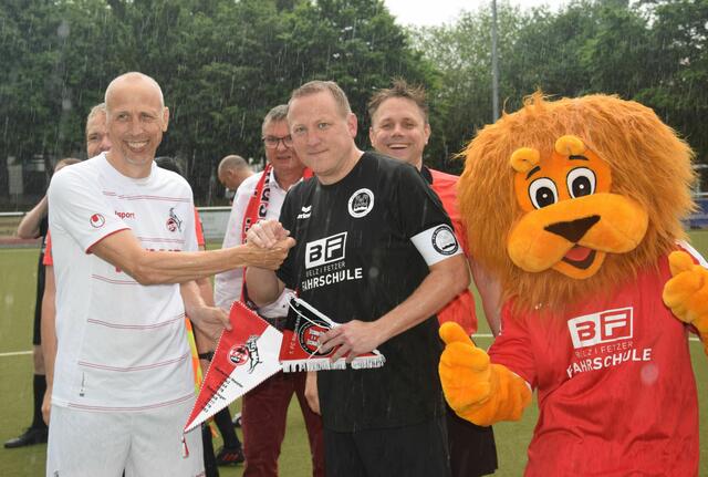 Strömender Regen konnte Spielfreude und gute Laune nicht verderben: die Mannschaftskapitäne Matthias Scherz (l.) und Holger Adenheuer (M.) mit Maskottchen, dahinter Bürgermeister Stephan Vehreschild und Schiedsrichter Marcus von Scheid.