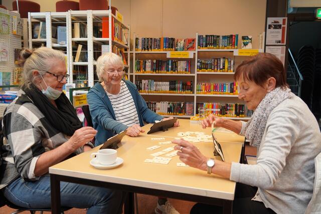 Umgeben von Büchern spielen diese Seniorinnen das Spiel Rummikub.  | Foto: Stadt Frechen