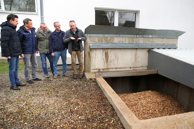 BioNet-Geschäftsführer Karl Hendrik Lenz (r.) erläutert am Hackschnitzel-Bunker die Anlage. Bürgermeister Ulrich Stücker, Klimaschutzmanager Torsten Richling, Geschäftsführer Thomas Baumhof und Hausmeister Heinz Peter Schenker (v.l.) sind aufmerksame Zuhörer.  | Foto: Christian Melzer