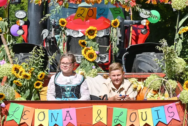 Das Kindererntepaar Leona und Louis hatte im Zug eine große Gefolgschaft. Sie wurden unter anderem begleitet von herbstlich mit Sonnenblumen kostümierten Kindern, Eltern und Erzieherinnen des Kindergartens Halft. | Foto: Herkenrath
