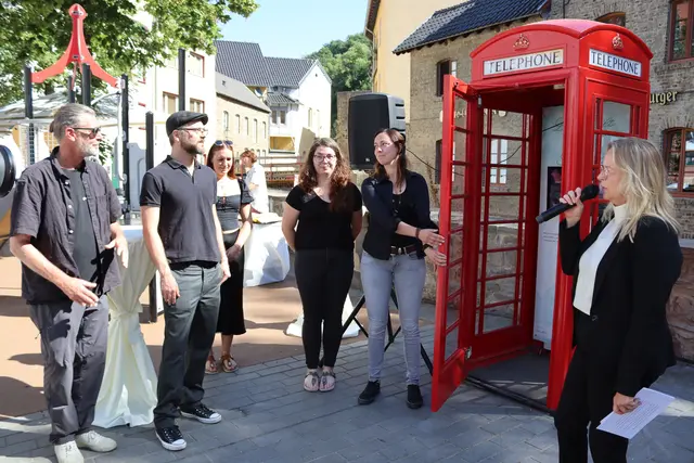 Mit den Fotografen Georg Wessel (v.l.) und Benjamin Fahl, den Mitarbeiterin der Tourist-Info Lea Schmitten, Michaela Kirchner, Sonja Aufdermauer sowie vielen weiteren Gäste feierte Bürgermeisterin Sabine Preiser-Marian (r.) der offizielle Eröffnung der neuen, roten Telefonzelle.  | Foto: Mager/Stadt Bad Münstereifel