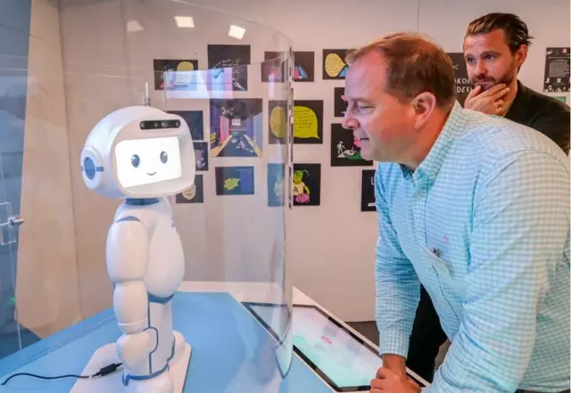 Marco Alfter (Geschäftsführer Dr. Hans Riegel-Stiftung) und Alexander Kukla (Stiftungsleitung) begrüßen den Lernroboter QT im Deutschen Museum Bonn.  | Foto: Dr. Hans Riegel-Stiftung/Roth