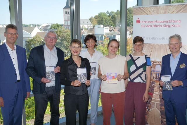 Regionalvorstand Ralf Klösges, Landrat Sebastian Schuster, Kirsten Felgner von der Kreissparkassenstiftung, Gabriele Paar, Vorsitzende des Beirates Kunst/Kultur der Kreissparkassenstiftung, Maren Diekmann, Geschäftsführung Frauenzentrum Troisdorf, Anouk Sterr, Geschäftsführung Frauenzentrum Bad Honnef und Christian Brand, Geschäftsführer der Stiftungen der Kreissparkasse Köln (von links) präsentieren die Klassik-Bühne.  | Foto: Woiciech