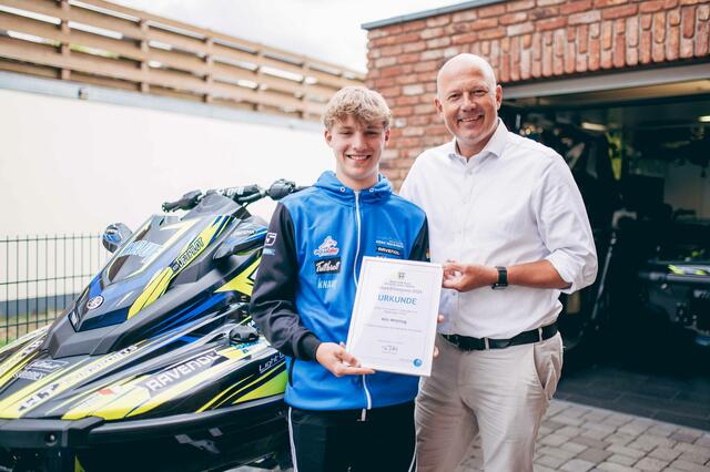 Nils Wittling und Landrat Rock mit der Urkunde des Talent-Ehrenpreises vor dem Jetski und der heimischen Garage.  | Foto: Rhein-Erft-Kreis