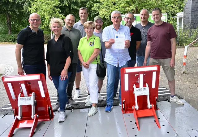 Vereinsvertreter der sechs beteiligten Vereine präsentieren stolz gemeinsam mit Bürgermeister Matthias Jedich, dem Landtagsabgeordneten Björn Franken und dem Bankvorstand eine Doppelsperre mit hoch gestellten Durchfahrsperren. | Foto: Steimel