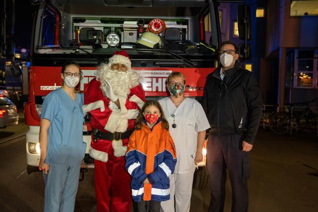 (v. l.): Assistenzärztin Clara Kißmann, Kinderherzchirurgie am UKB, Weihnachtsmann und Pflegerische Leitung Kindernotfallzentrum am UKB Christian Agyemang, eine kleine Zuschauerin des ELKI-Lichterfests, Schwester Kathrin Oester, Kinderherzchirurgie am UKB, und Martin Haselbauer, Leiter der Werkfeuerwehr des UKB nach der gelungenen Veranstaltung.