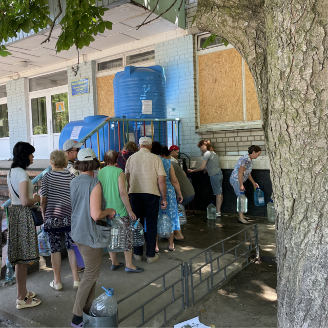 An einer Verteilstation stehen Menschen für Wasser an.  | Foto: Stadt Nikopol
