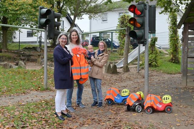 Petra Nöhring vom St. Franziskus Krankenhaus, Silke Hakelberg und Carina Güldenring (v.li.) vom Kindergarten trafen sich zur Übergabe der gesponsorten Warnwesten an der Ampelkreuzung vor dem „Fuhrpark“ des Kindergartens Harmonie. | Foto: Herkenrath