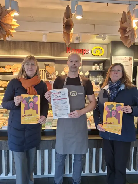 „Gewalt kommt uns nicht in die Tüte“: Die Bonner Gleichstellungsbeauftragte Stephanie Clemens-Krämer, Alexander Köhl, selbstständiger Franchisepartner Kamps GmbH, und Vize-Gleichstellungsbeauftragte Katja Schülke zeigen die Tüten, die am Tag gegen Gewalt an Frauen in den teilnehmenden Bäckereien ausgegeben werden.  | Foto: Bundesstadt Bonn