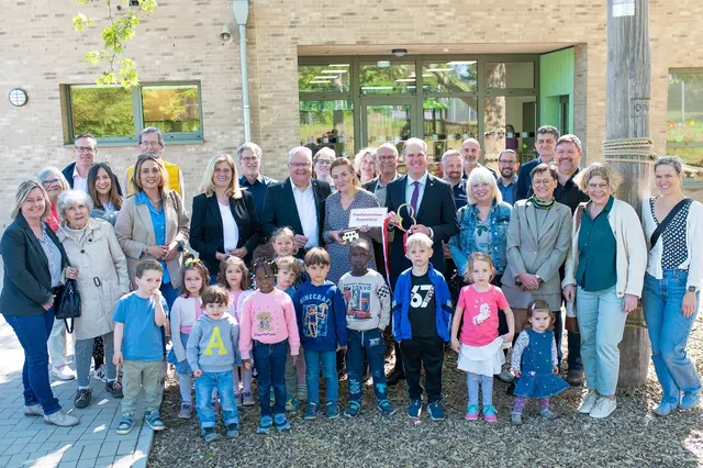 Bürgermeister Dirk Breuer (5. von links) übergibt symbolisch den Schlüssel an Kitaleiterin Sabrina Junghans-Löhe (links neben ihm) im Beisein des Ersten Beigeordneten Jens Menzel, dem Vorsitzenden des Jugendhilfeausschusses Thomas Klug und weiteren Vertreterinnen und Vertretern von Politik und Verwaltung sowie einigen Kindern der Kita Burgwichtel.  | Foto: Stadt Hürth/Giuseppe Piliero