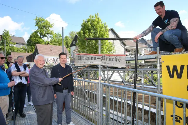 Dietrich Wirths freut sich mit Bürgermeister Ulrich Stücker und Tiefbauamtsleiter Pascal Hilgenberg (r.), dass das von ihm geschaffene Schild in frischer Optik wieder die Brücke ziert.  | Foto: Christian Melzer