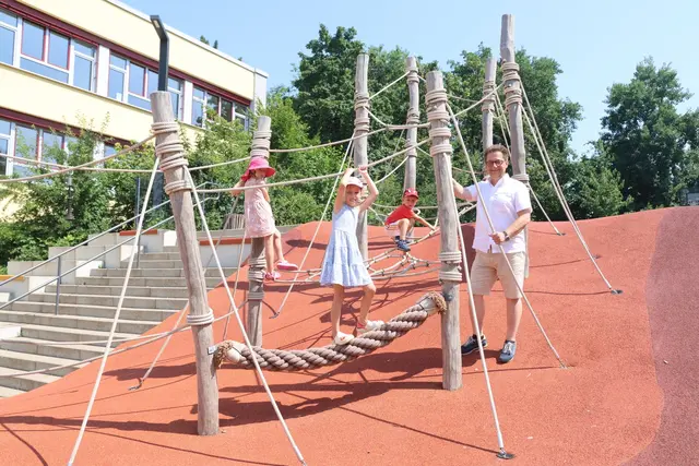 Lilly (5), Elina (8) und Mateo (4) mit Architekt Markus Schürmann auf dem Kletterparcours, der die beiden Schulhofebenen verbindet | Foto: Michael Kupper
