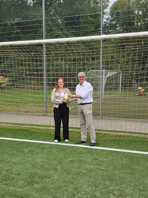 Begutachten den erneuerten Kunstrasenplatz im Schlossparkstadion: Annika Kluth, Sachbearbeiterin Schule und Sport, und Bürgermeister Dr. Marc Prokop. Der neue Belag wurde bereits im Juni für den Sportbetrieb freigegeben.  | Foto: Stadt Brühl