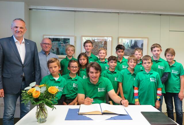 Eintrag ins Goldene Buch – (v.l.) Bürgermeister Jörg Schmidt, Herbert Adomeit, die Spielerinnen und Spieler der U10- und U12-Schachjugend sowie (vorne) Trainer Frederik Schade. | Foto: Gemeinde Wachtberg/mm