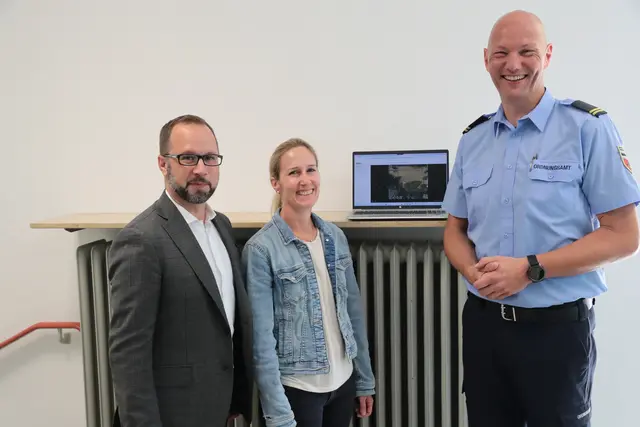 Der Bildschirm zeigt Menschen auf dem Schulhof an. Vlnr. zeigen Ralf Bockhecker, Chantal Roos, die zuständige Sachgebietsleiterin im Ordnungsamt, und Sascha Hessenbruch die Leistungsfähigkeit der neu eingesetzten Technik. | Foto: we