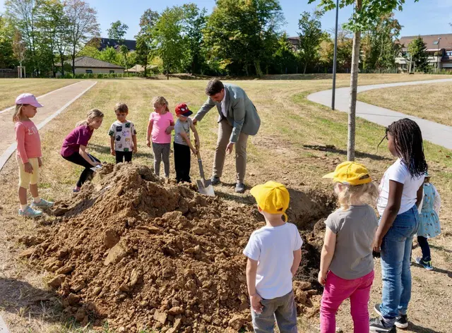 Zur Eröffnung pflanzte Bürgermeister Biber mit Kindern aus der Nachbarschaft symbolisch einen Baum.  | Foto: Stadt Troisdorf