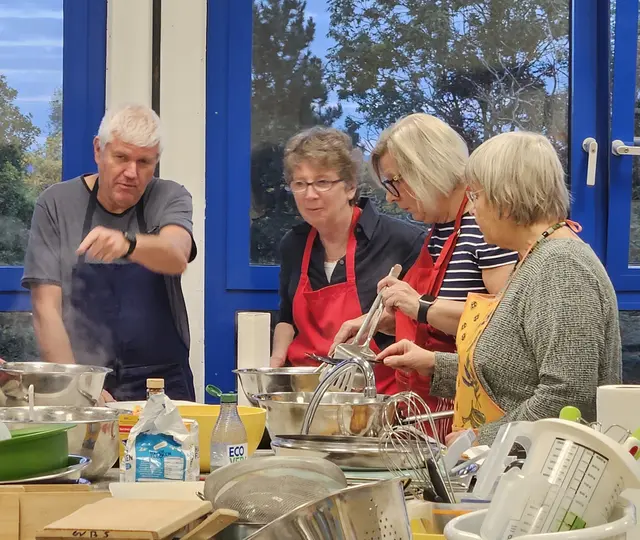Rosemarie Hallynck und Petra Kalkbrenner – die Bürgermeisterinnen aus Quesnoy-sur-Deûle und Swisttal – stehen gemeinsam am Herd: Beim Jubiläumswochenende der Städtepartnerschaft bereiten sie in der Schulküche Reibekuchen zu.  | Foto: Partnerschaftsverein