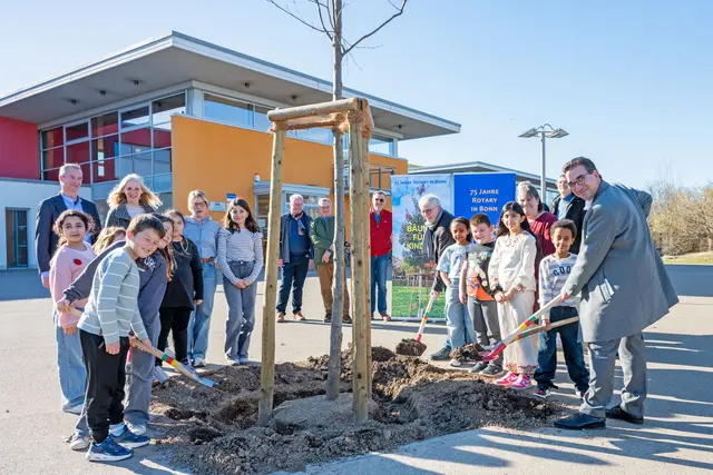 Kinder der Jahnschule, Oberbürgermeister Guido Déus (r.) und Dr. Thomas Zeit, Präsident des Rotary Clubs Bonn (7.v.r.) schlossen die Baumpflanzung mit dem Verfüllen des Pflanzrings einer der drei Bäume mit Erde ab.  | Foto: Sascha Engst/Bundesstadt Bonn