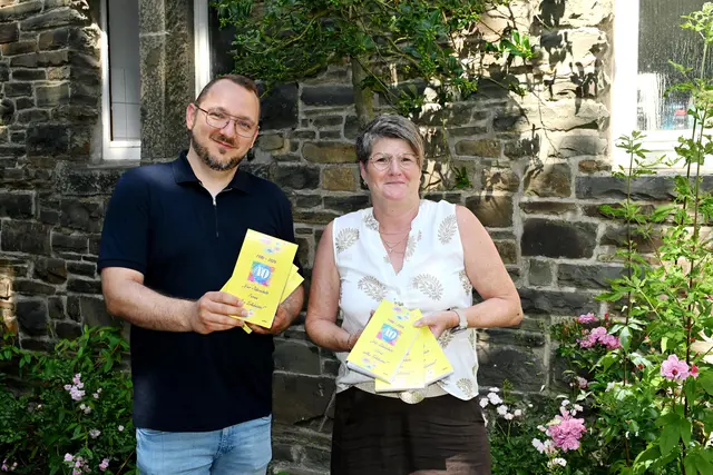 Bürgermeister Matthias Jedich präsentiert den Jubiläumspass. Mit ihm freut sich Petra Hupperich, bei der im Rathaus seit Wochen die Fäden zusammenliefen. Sie hat alle Angebote im Pass umgesetzt. | Foto: Steimel