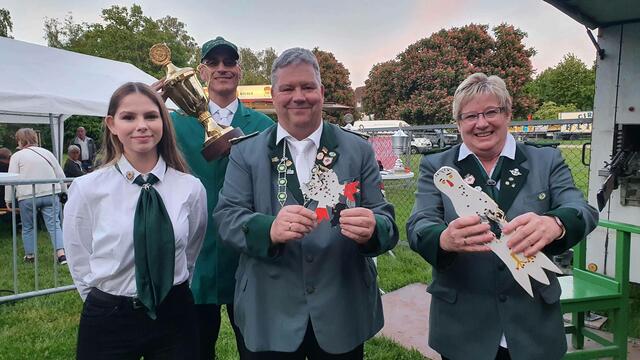 Jungschützin Gina (von links) freute sich mit ihrem Vater Andreas Zimpel über dessen Titelgewinn als neuer König der Quettinger Sankt Sebastianus-Schützenbruderschaft. Als erste Hutkönigin konnte sich Monika Tietze in die Annalen der Vereinsgeschichte eintragen, während Boris Weistroffer (im Hintergrund) den Paul Hebbel-Jubiläumspokal errang.  | Foto: Gabi Knops-Feiler