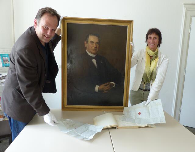 Julius Leonhard und Annette Junker mit den Briefen und dem Portrait von Carl Leverkus.  | Foto: Stadt Leverkusen