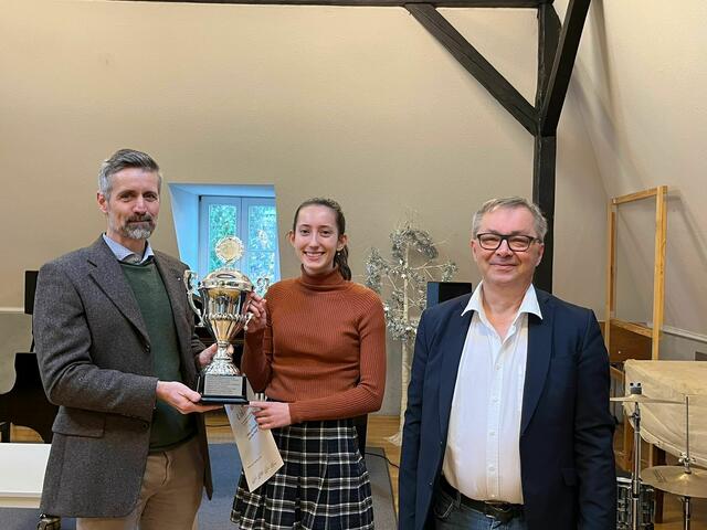 Stolz nimmt Pianistin Sarah Moritz (Mitte) den Wanderpokal der KuMs entgegen. Überreicht wurde er von Dr. Thomas Pelster, Präsident des Rotary Club Brühl, und Karel Jockusch, Fachleiter und Dozent an der Kunst- und Musikschule der Stadt Brühl (von links). | Foto: Stadt Brühl